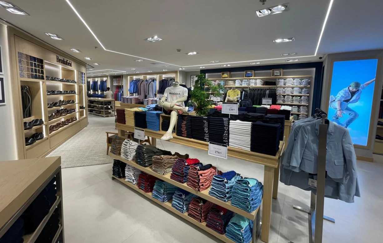 Interior da Brooksfield no Shopping Ponta Negra, com iluminação linear, marcenaria e exposição de produtos executados pela GEO